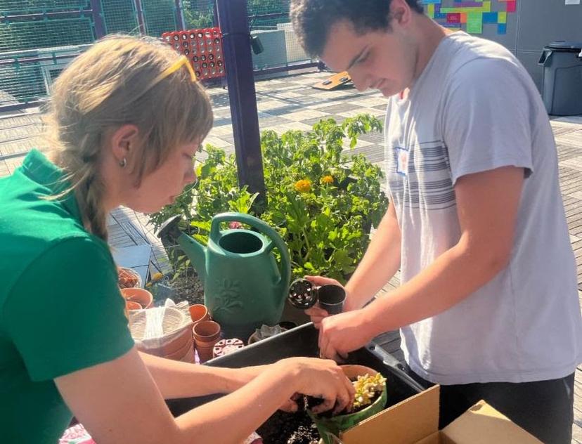 Two members prepare plants for The Friendship Circle's rooftop garden.