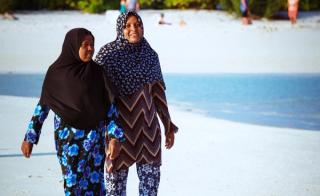 Two woman walking on a beach in the Maldives