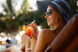 Woman drinking a cocktail at the beach