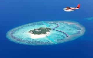 Sea plane flying above Maldives islands, Raa Atoll