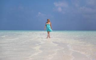 Pregnant woman walking on a beach in the Maldives