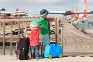 Children with luggage looking at seaplanes