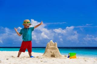 Child building a sand castle in Maldives