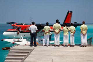 Seaplane at arrival jetty with staff