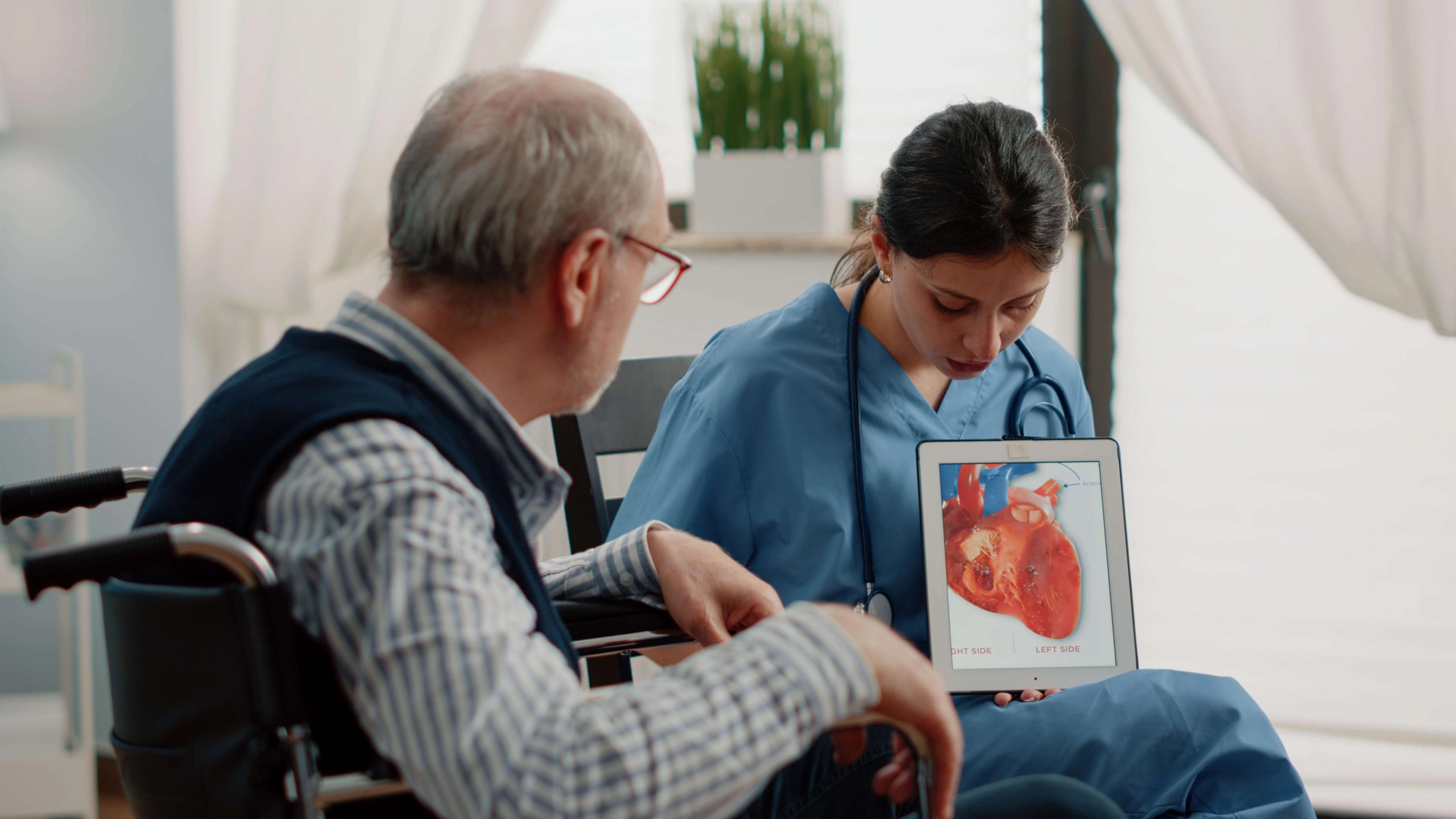 Infirmière tenant une tablette avec un cœur, diagnostic cardiologique