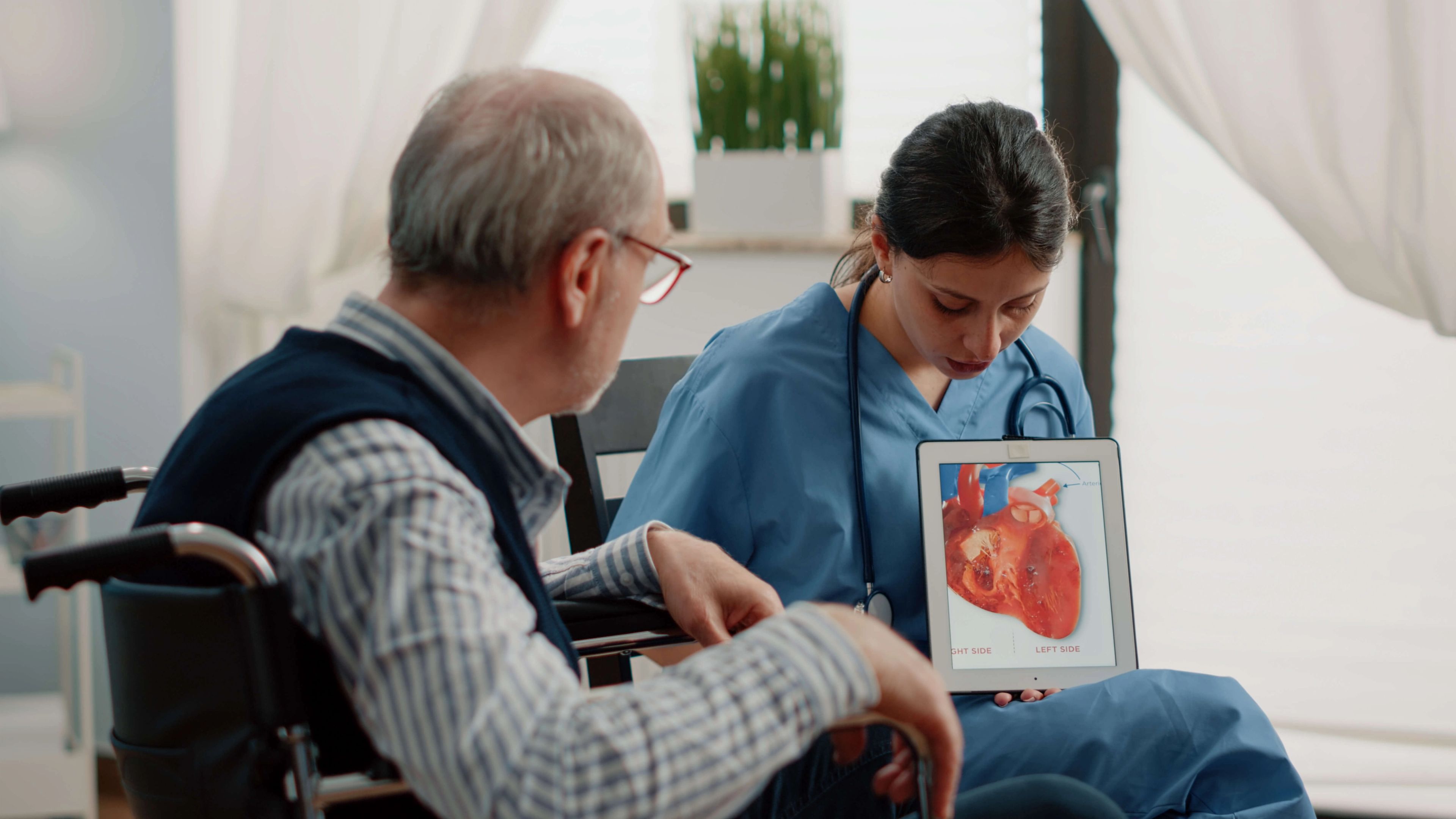 Infirmière tenant une tablette avec un cœur, diagnostic cardiologique
