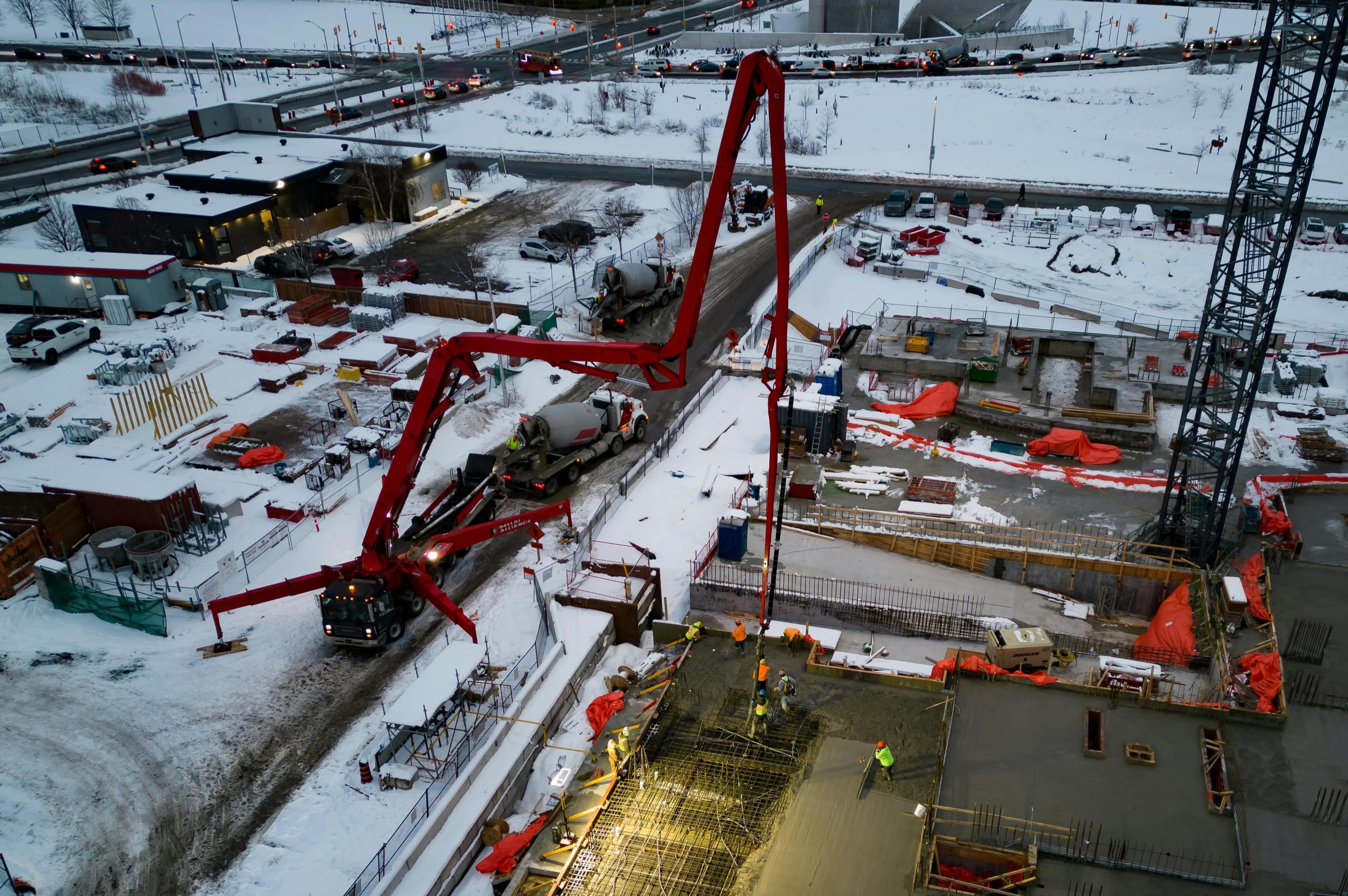Roter Ladekran auf Baustelle im Winter