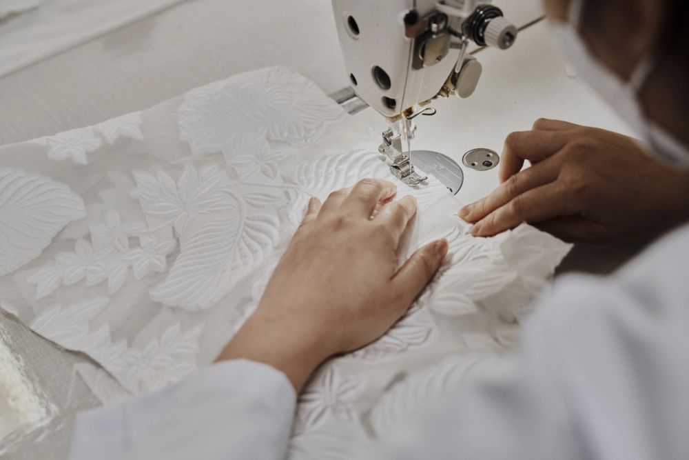 Sewing a gown detail on an industrial machine at the atelier