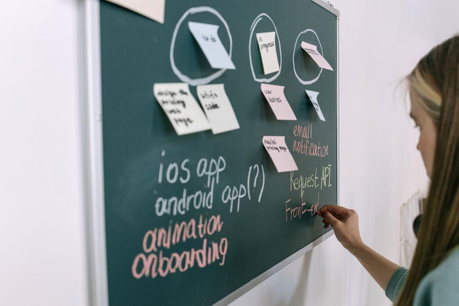 A collaborative software engineering team working in a modern office with whiteboards and digital screens - agile app