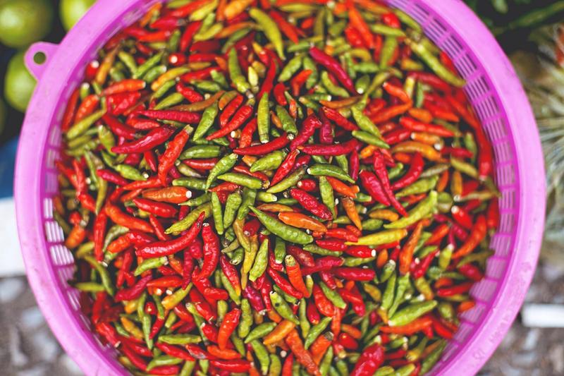 A bucket of small red and green chilis