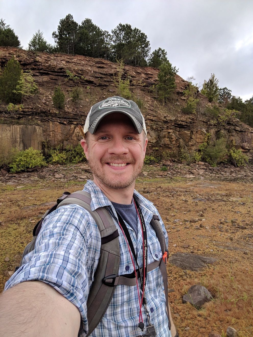 Dr Brian Burnham standing in front of a geological exposure.