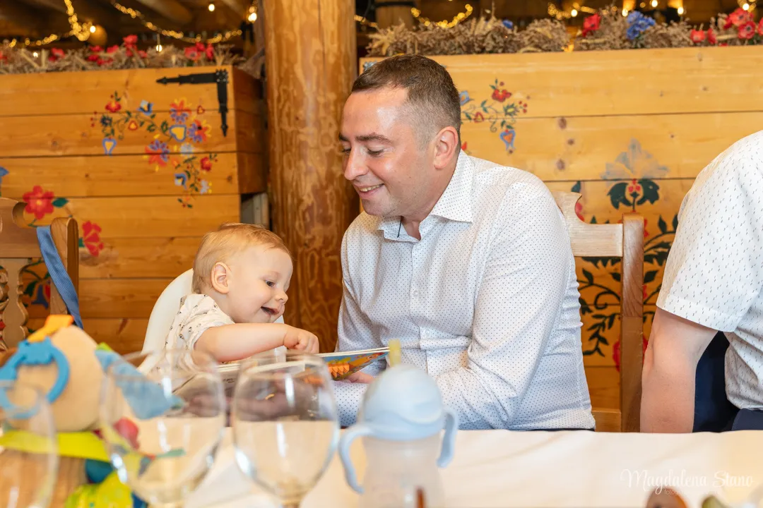 tata-i-dziecko-smieja-sie-tata-pokazuje-ksiazke-reportaz-przyjecie-chrzest