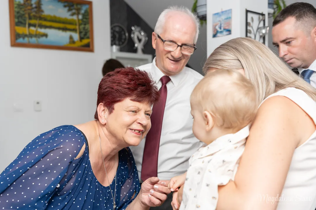 fotografia-chrzest-wielopokoleniowa-dziadkowie-z-mama-i-dzieckiem-babcia-trzyma-za-dlon