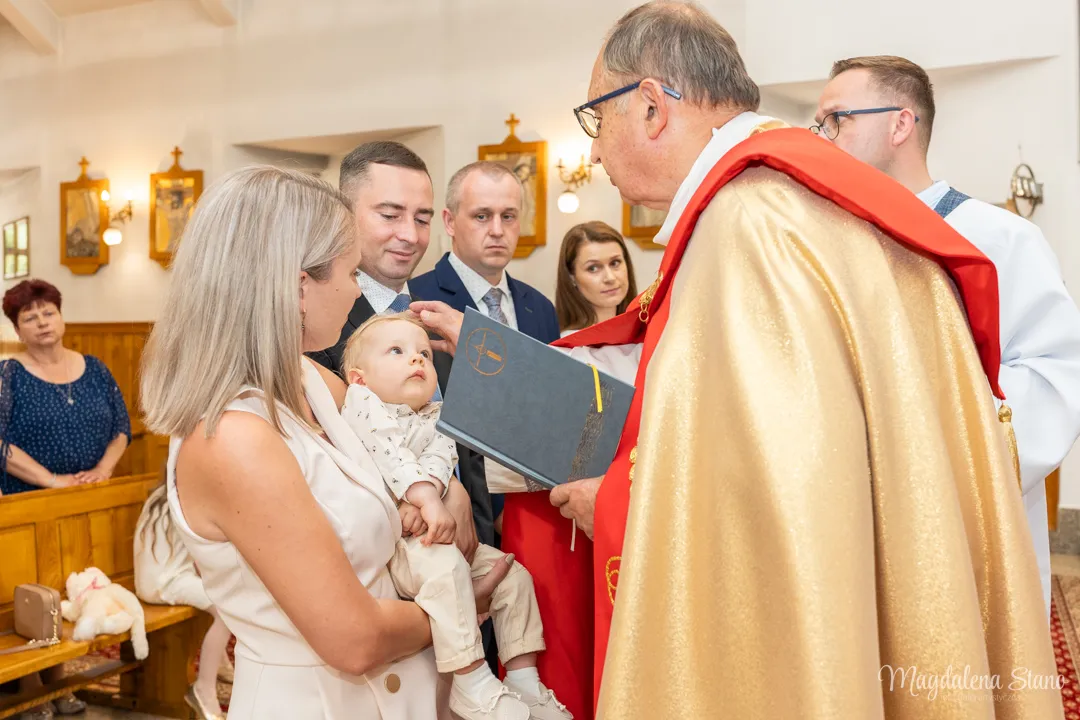 fotograf-na-chrzciny-ksiadz-daje-znak-krzyza-na-czole-dziecka-rodzice-i-chrzestni-sa-obok