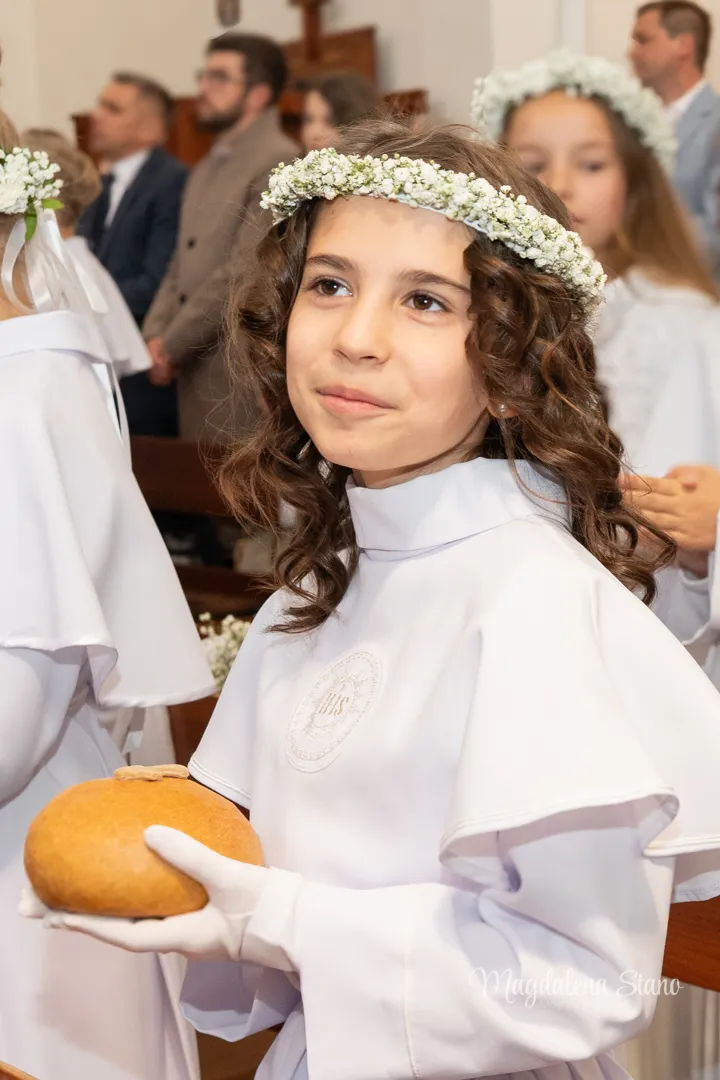 Fotograf na Komunię Świętą w Krakowie i okolicach: Reportaż z sesji klasowych i indywidualnych. fotograf-komunia-indywidualna-krakow-portret-dziewczynka-usmiechnieta-z-chlebem