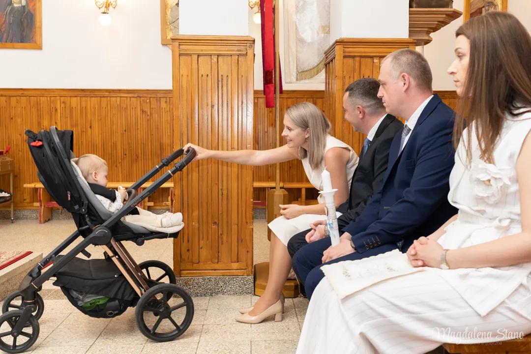  fotograf-na-chrzciny-rodzice-i-chrzestni-siedza-w-kosciele-mama-porusza-wozkiem