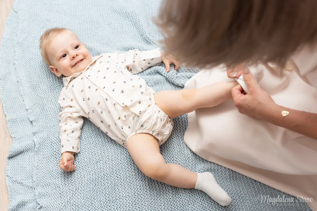 mama-ubiera-dziecku-skarpetke-zdjecie-nogi-dziecka-fotograf-na-chrzciny