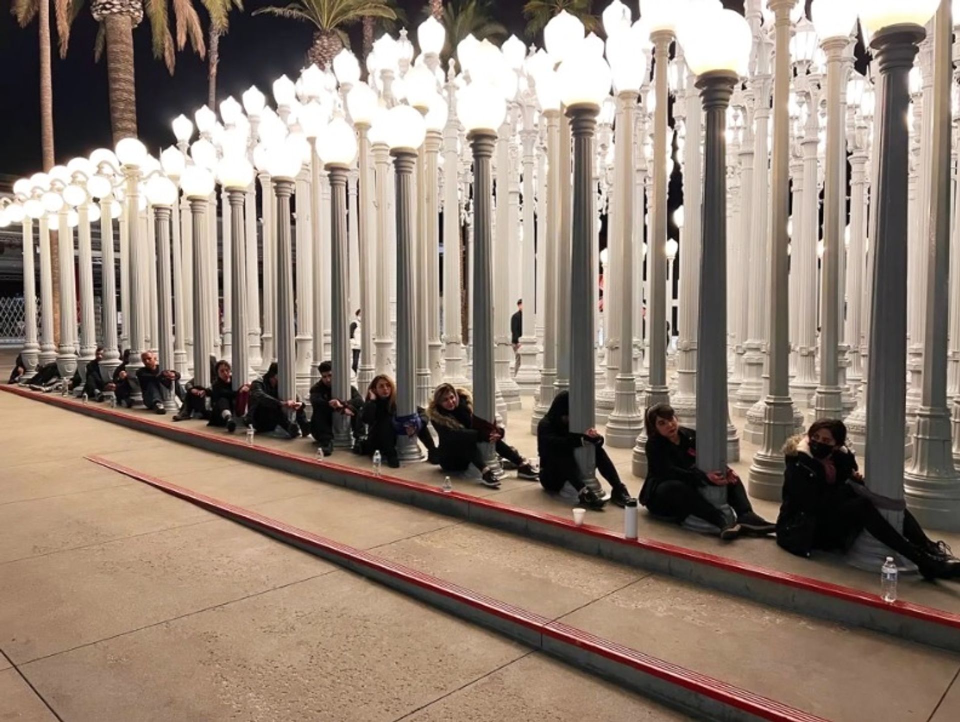 המפגינים אזקו את עצמם לתאורה האורבנית המהוללת של כריס בורדן (2008) ב"מוזיאון לאמנות" של מחוז לוס אנג'לס

באדיבות מפגינים