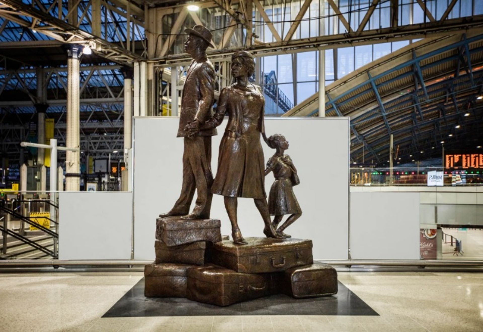 עבודתו של בזיל ווטסון בתחנת ווטרלו בלונדון מציגה גבר, אישה וילד מטפסים על הר של מזוודות, יד ביד

קרדיט: בזיל ווטסון
