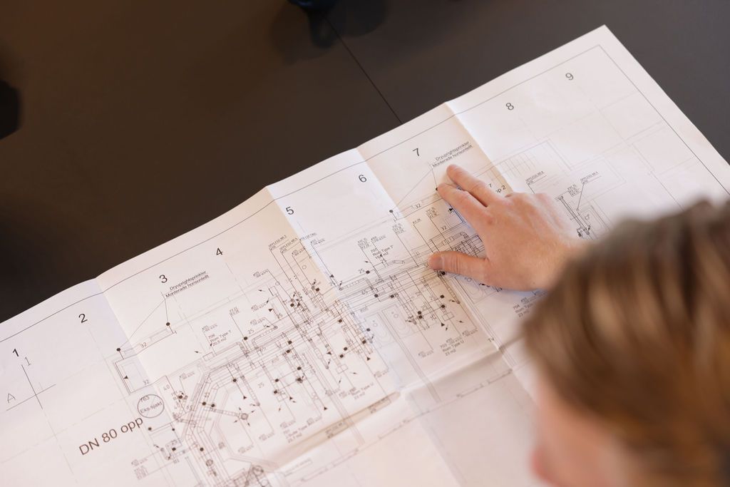 Hånd peker på punkt i plantegning