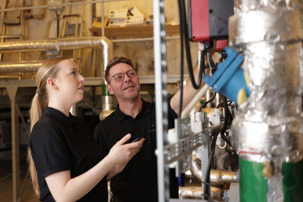 Kvinne og mann ser på maskin