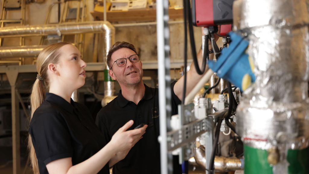 Kvinne og mann ser på maskin