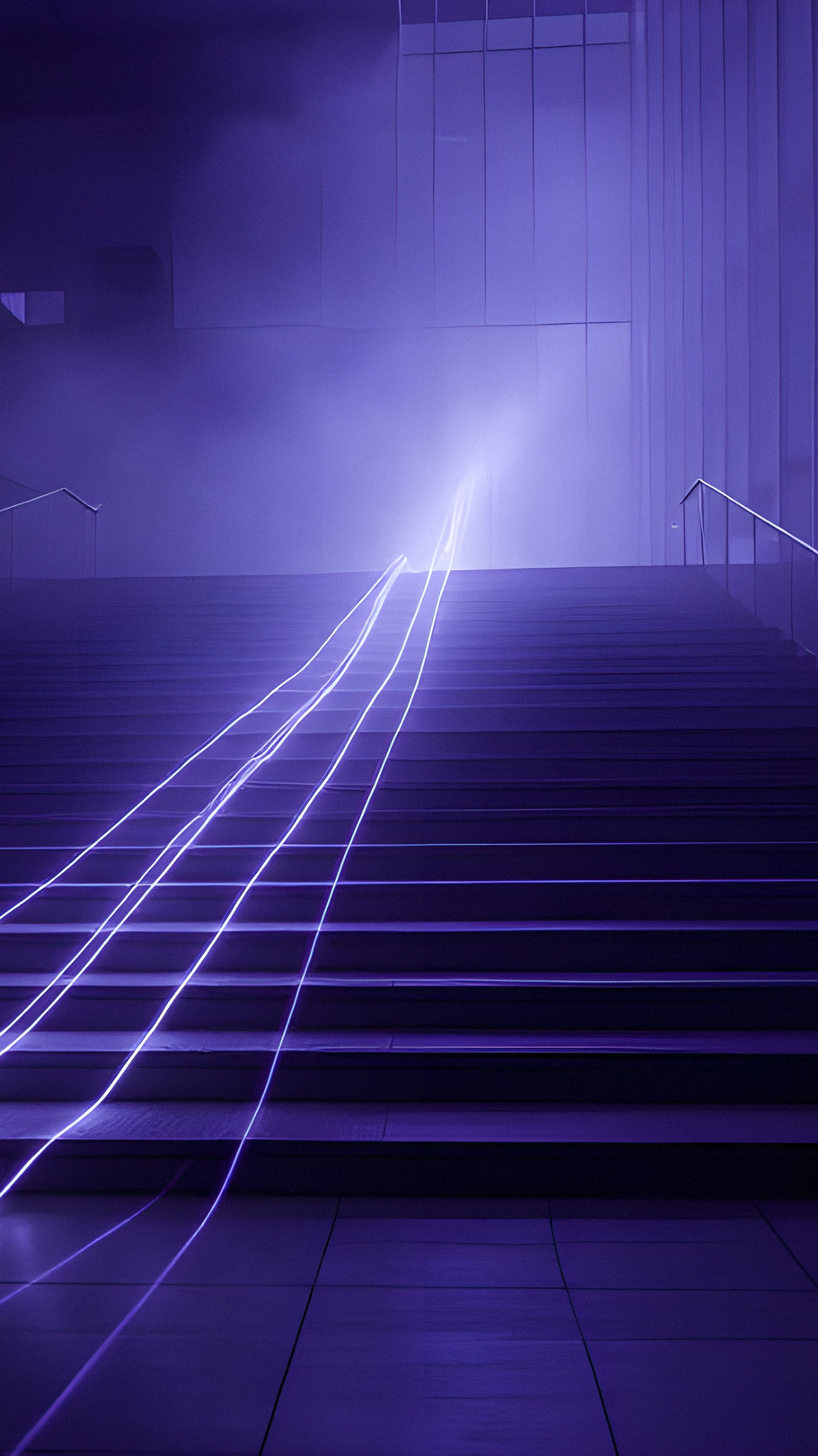 Lines of light rising up a wide flight of stairs in a dark atrium
