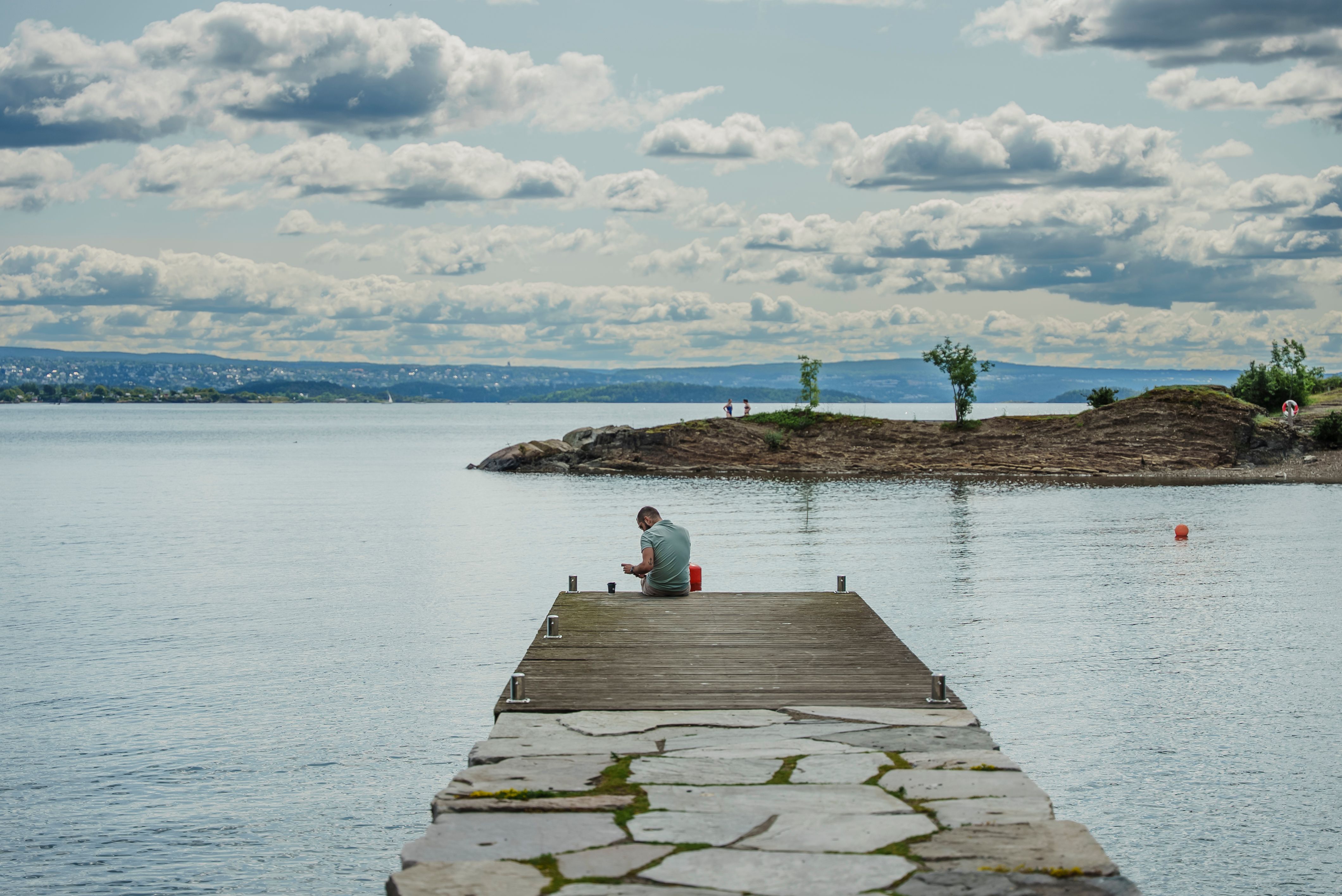 Bilde av person på brygga med fjorden i bakgrunnen