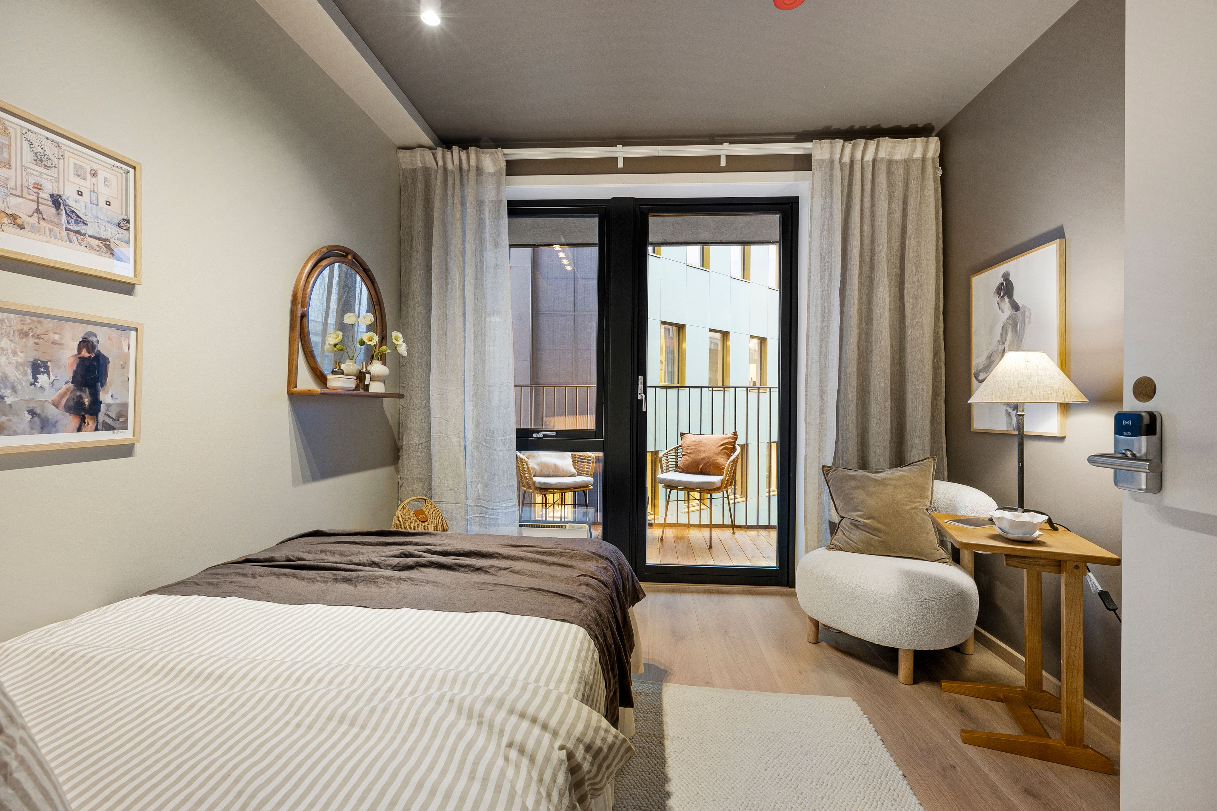 Soverom med seng, skrivepult og utgang til balkong.