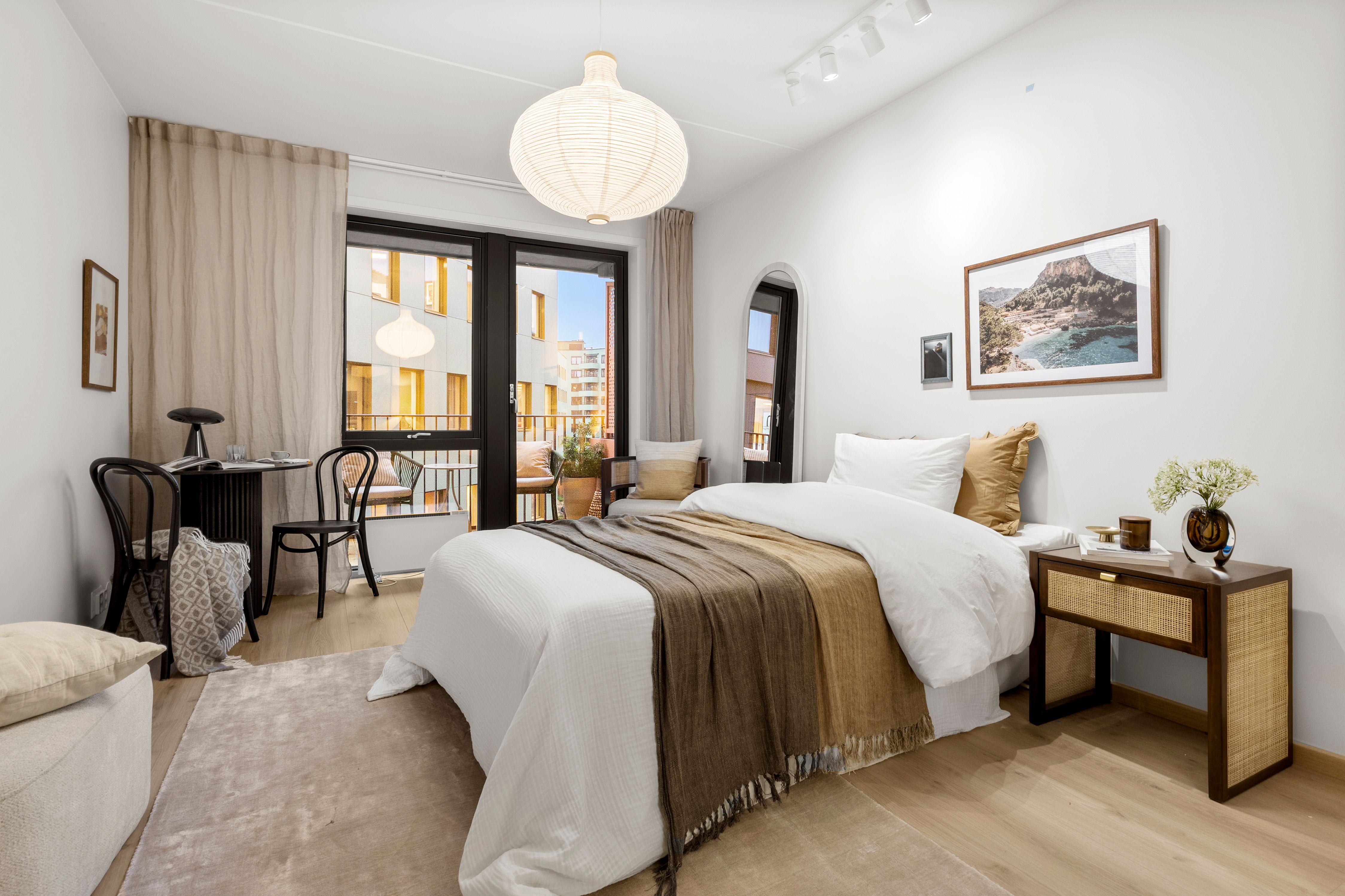 Soverom med seng, nattbod og egen sittegruppe.