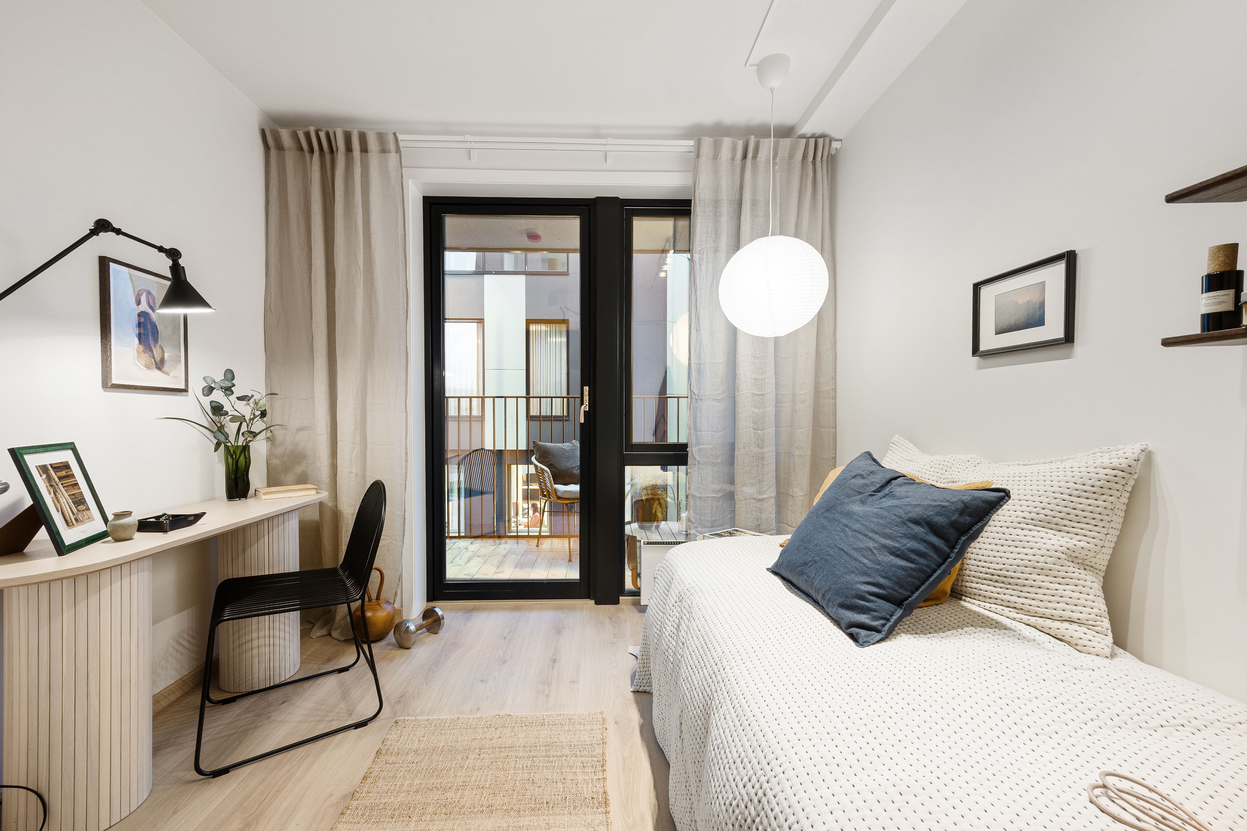 Soverom med seng, skrivepult og utgang til balkong
