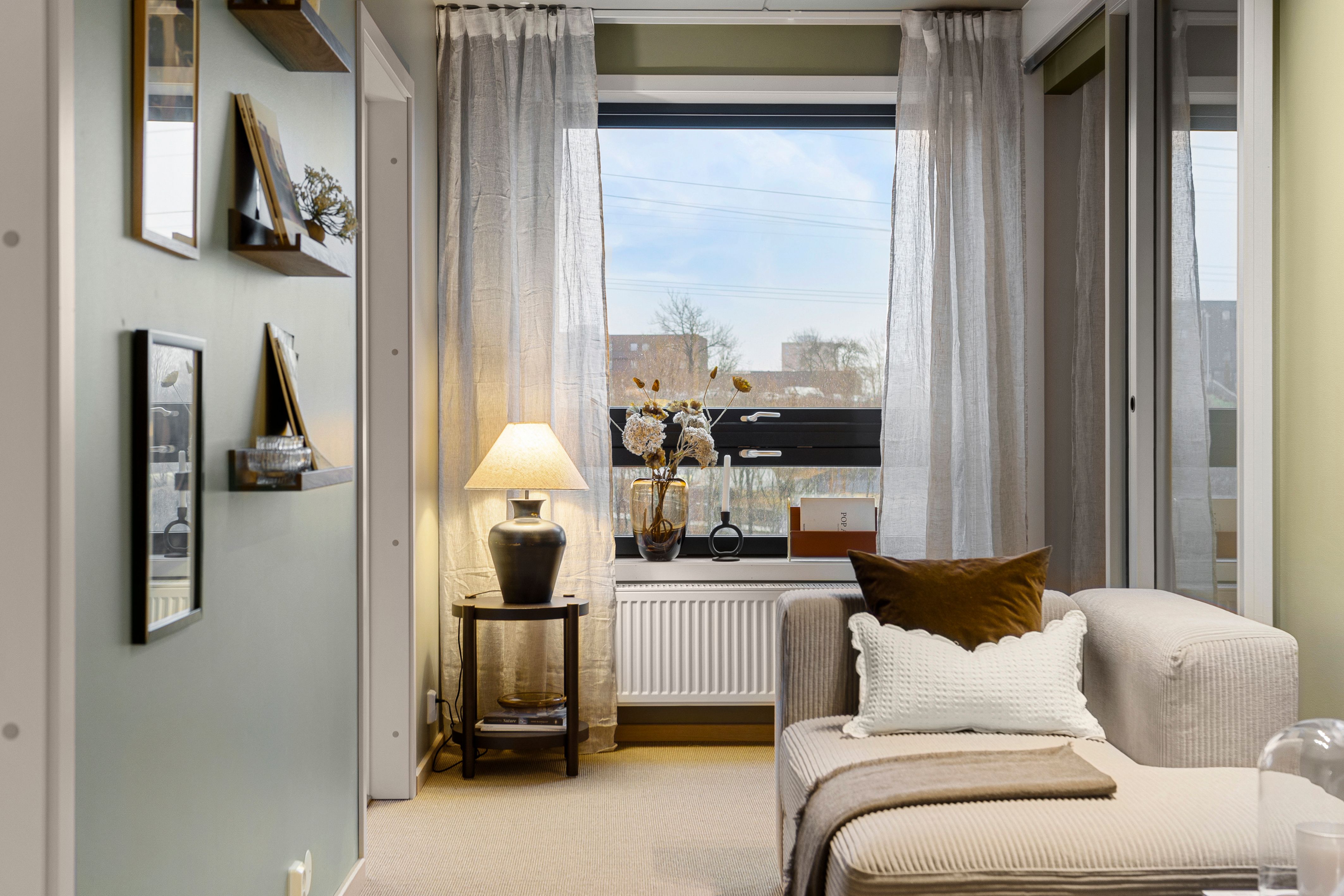 Stue med sofa og liten lampe. Vindu og skyvedør