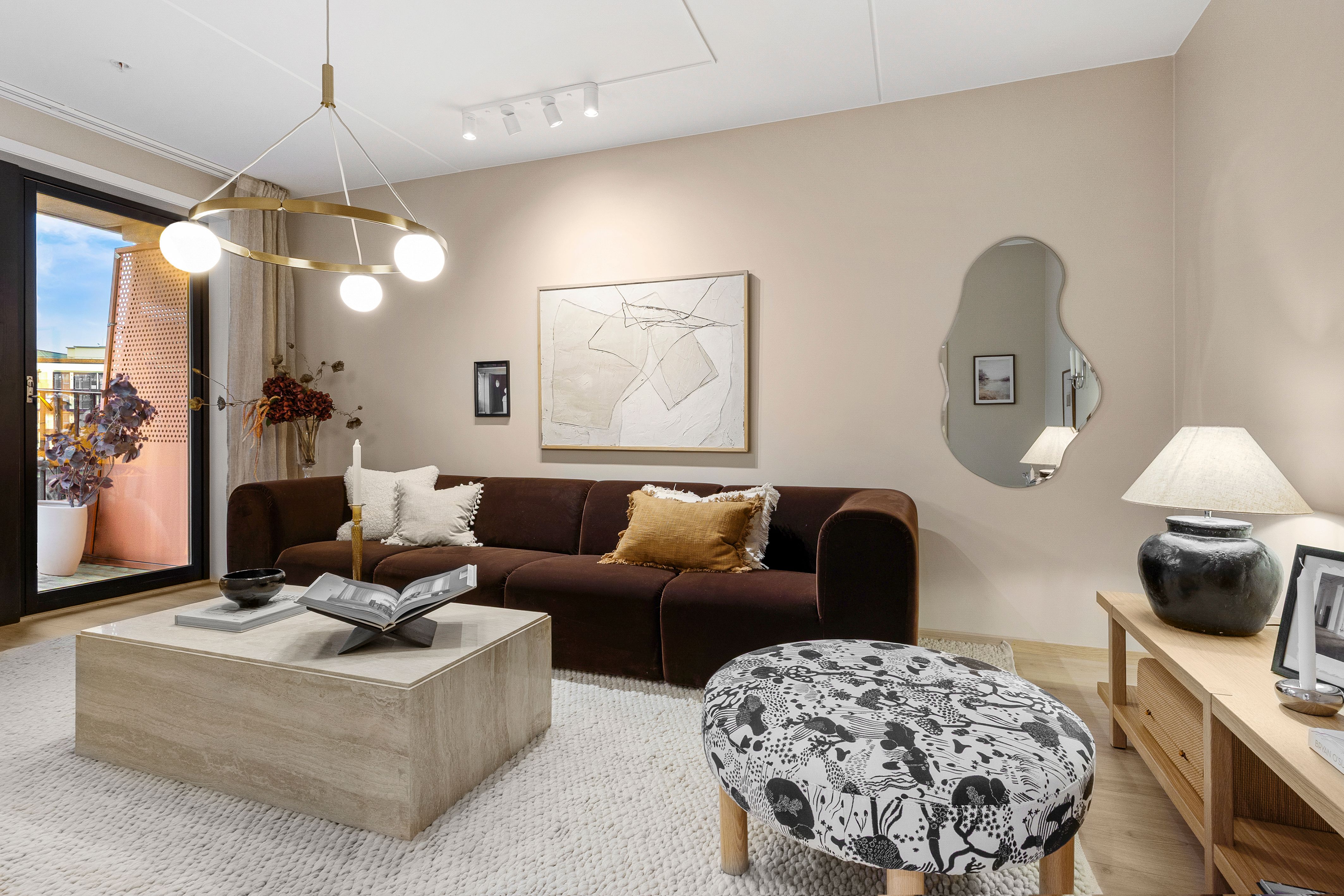 Stue med sofa, sofabord og puff.