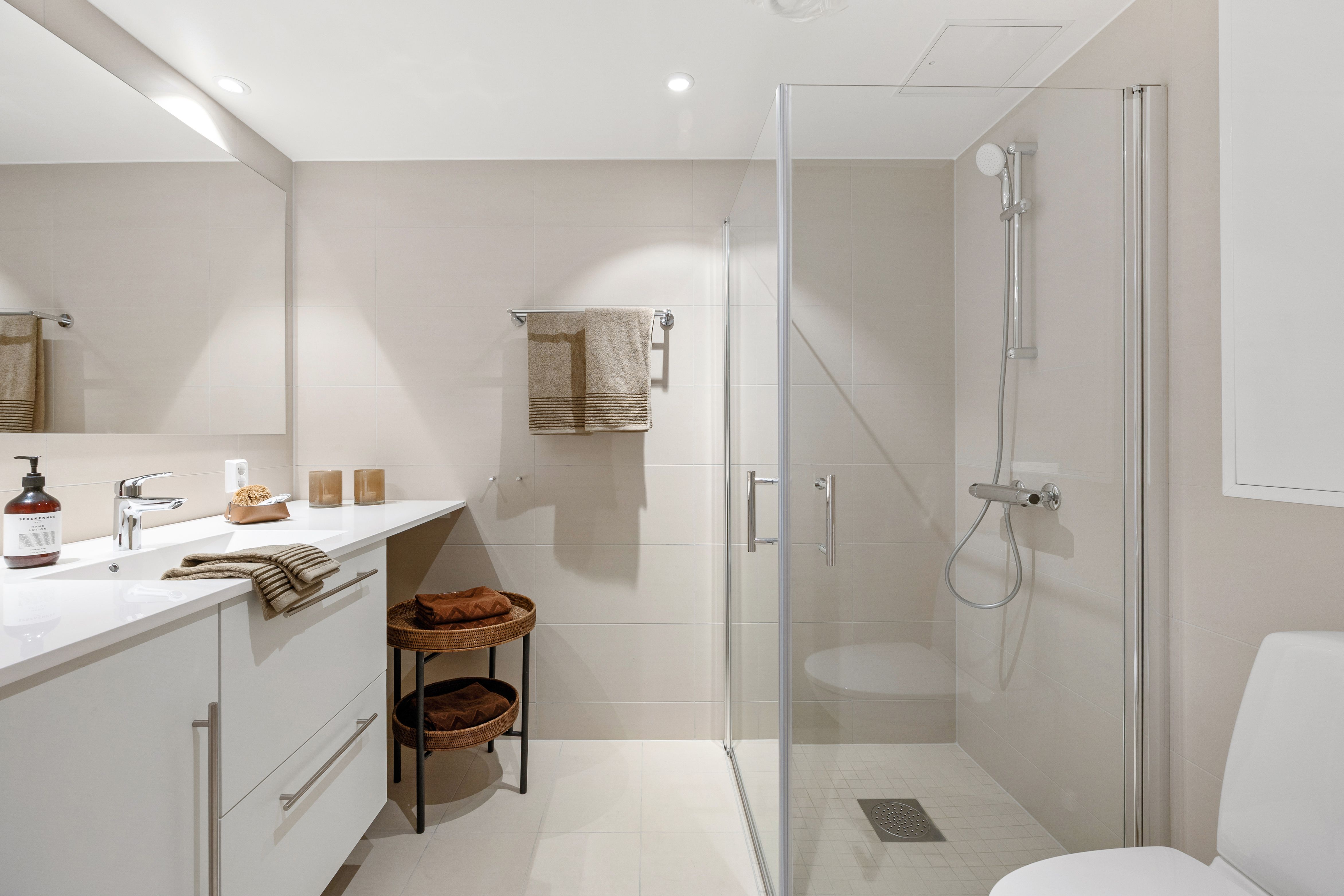 Bad med baderomsinnredning, dusjhjørne og toalett.