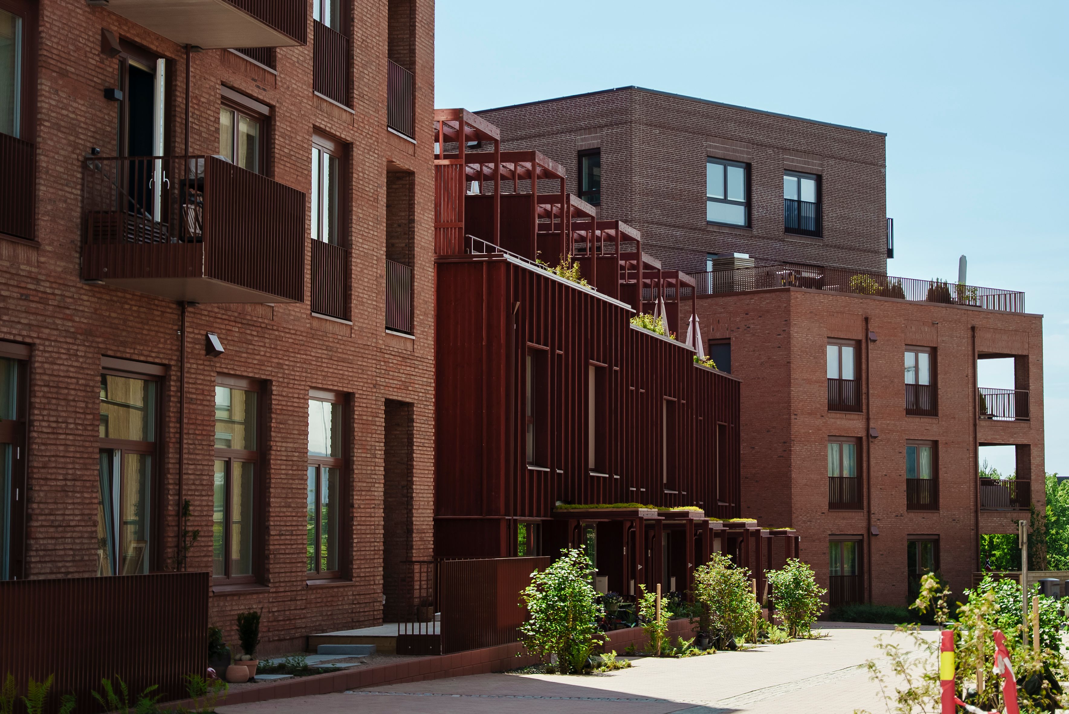 Rødbrun fasade på Nansenløkka med gangvei i forgrunnen