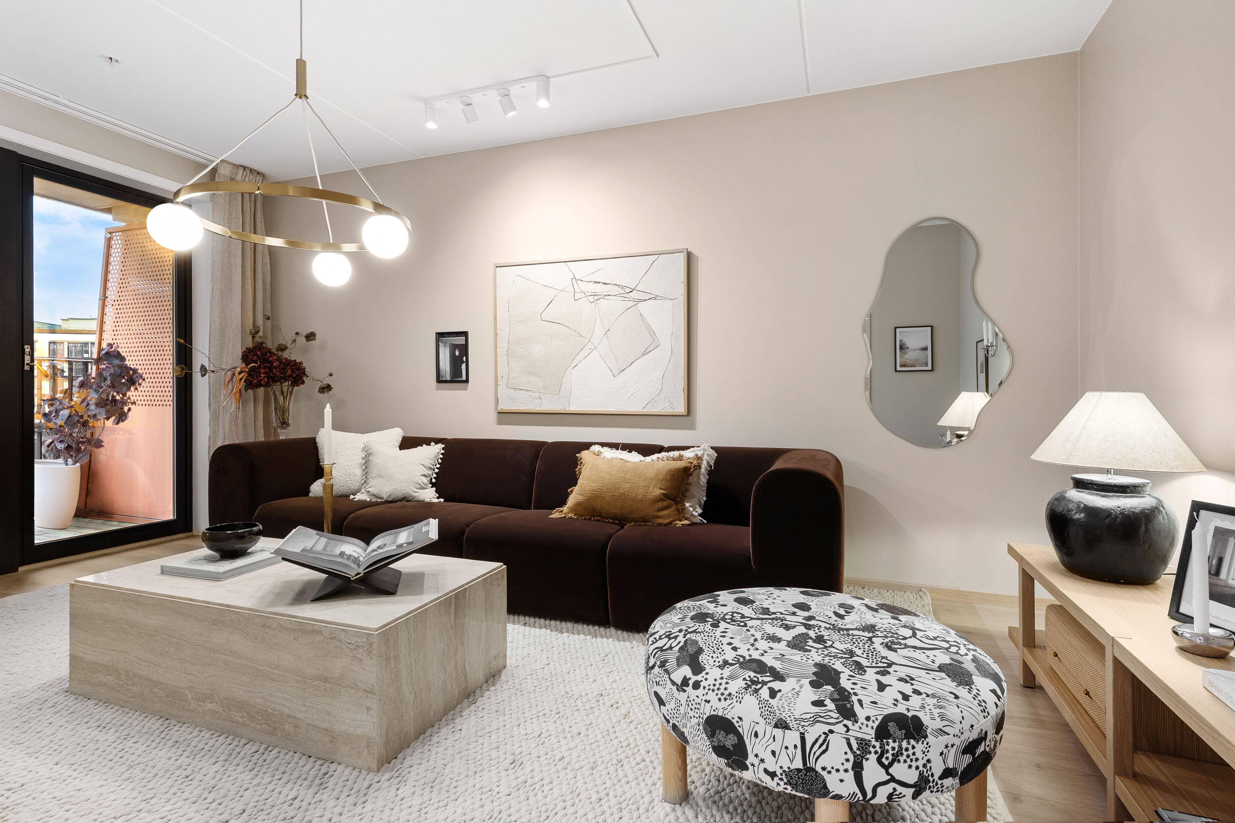 Stue med sofa, sofabord og puff.