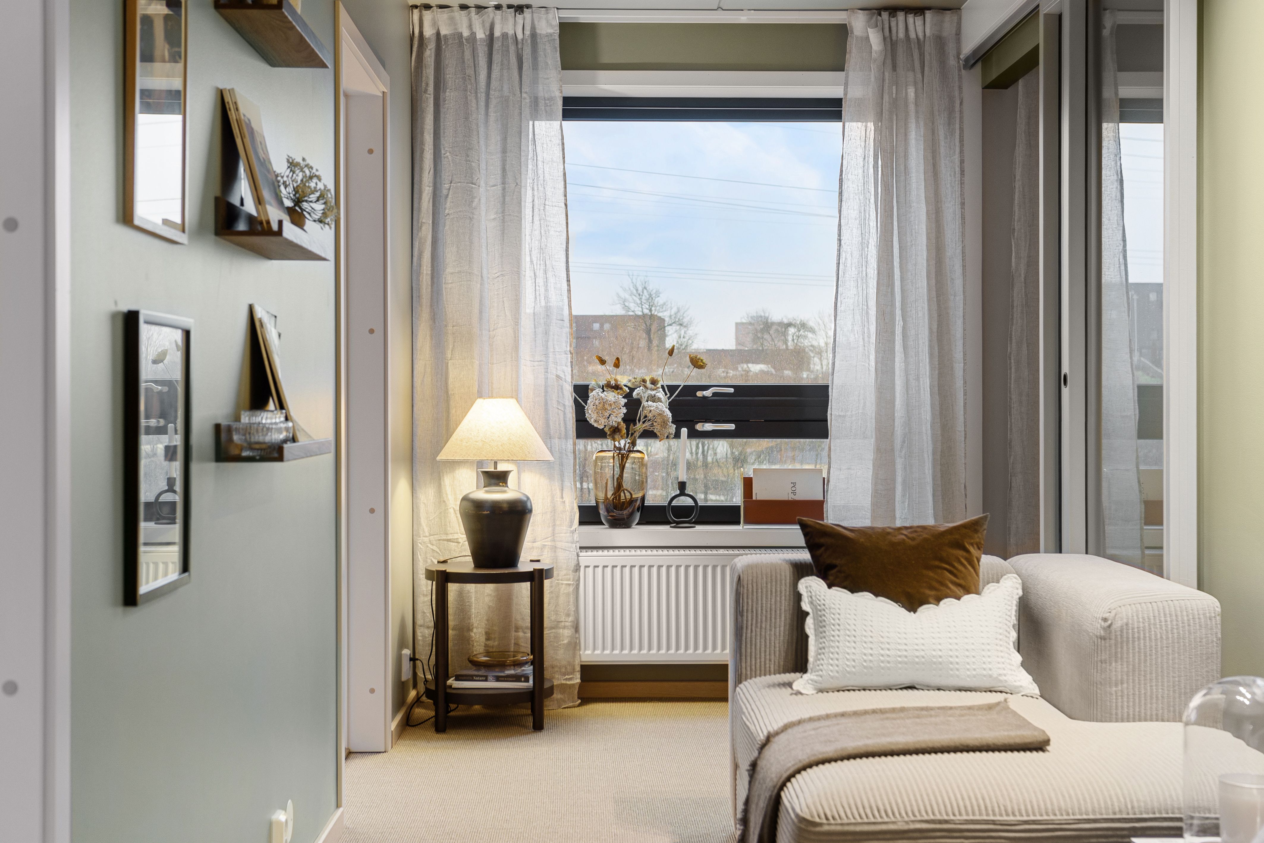 Stue med sofa og liten lampe. Vindu og skyvedør