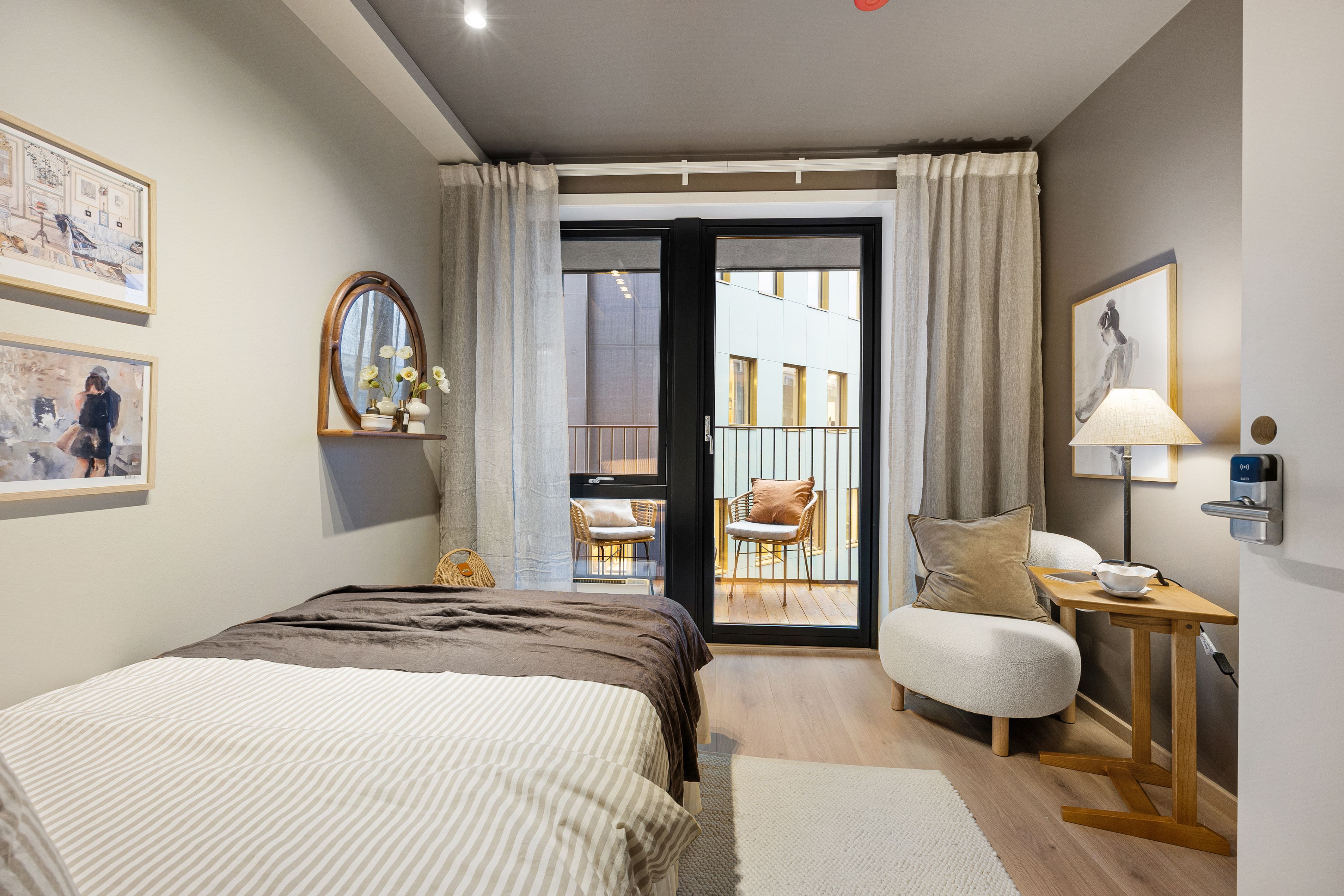 Soverom med seng, skrivepult og utgang til balkong.