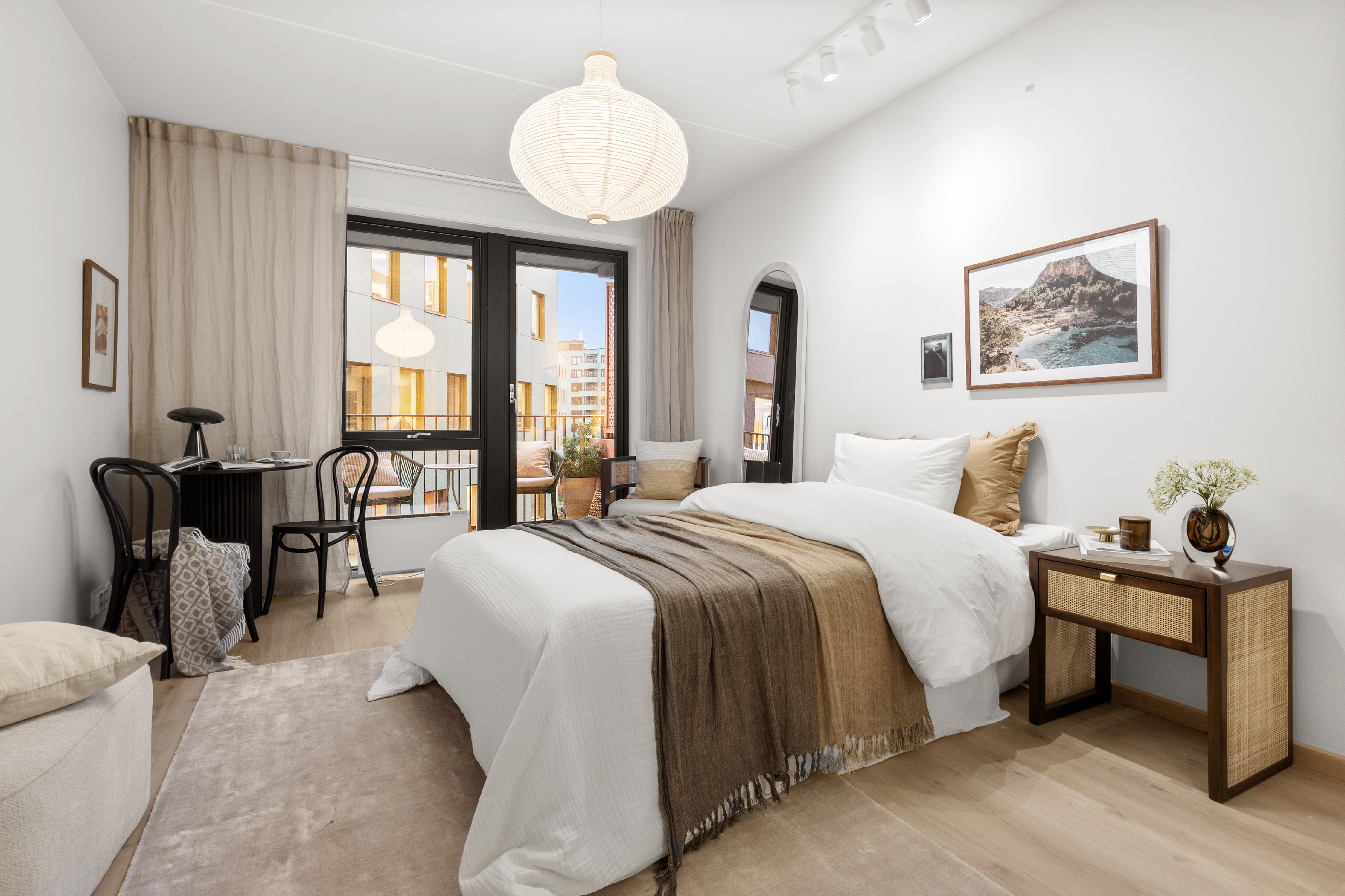 Soverom med seng, nattbod og egen sittegruppe.