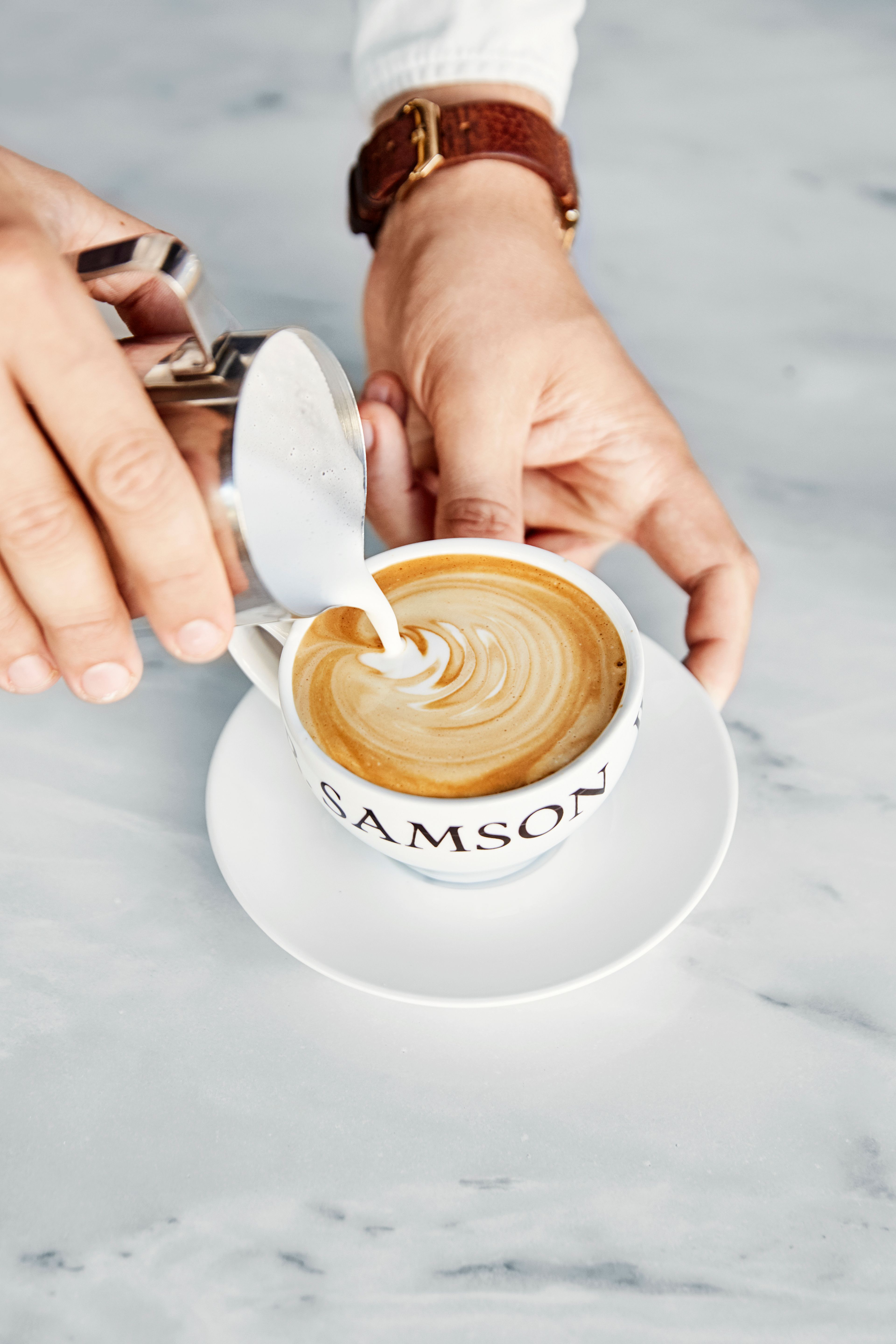 En som fyller opp en kopp kaffe