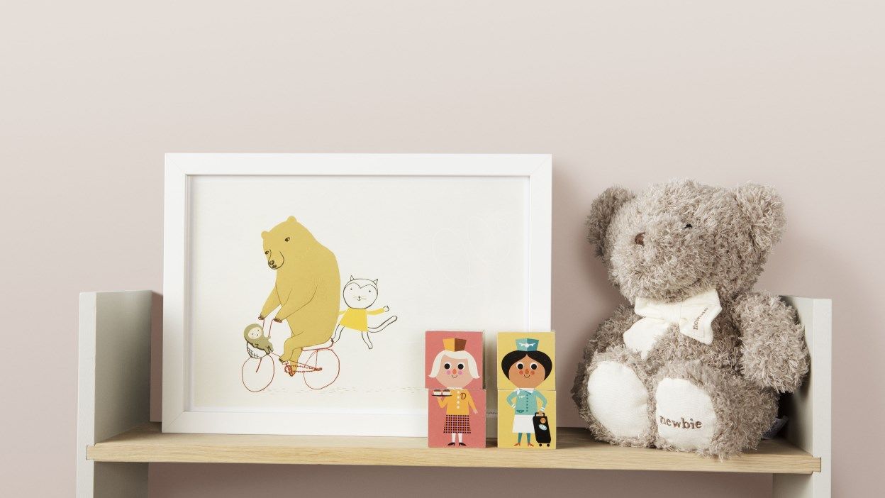 Et bilde og en bamse på en hylle. Foto.