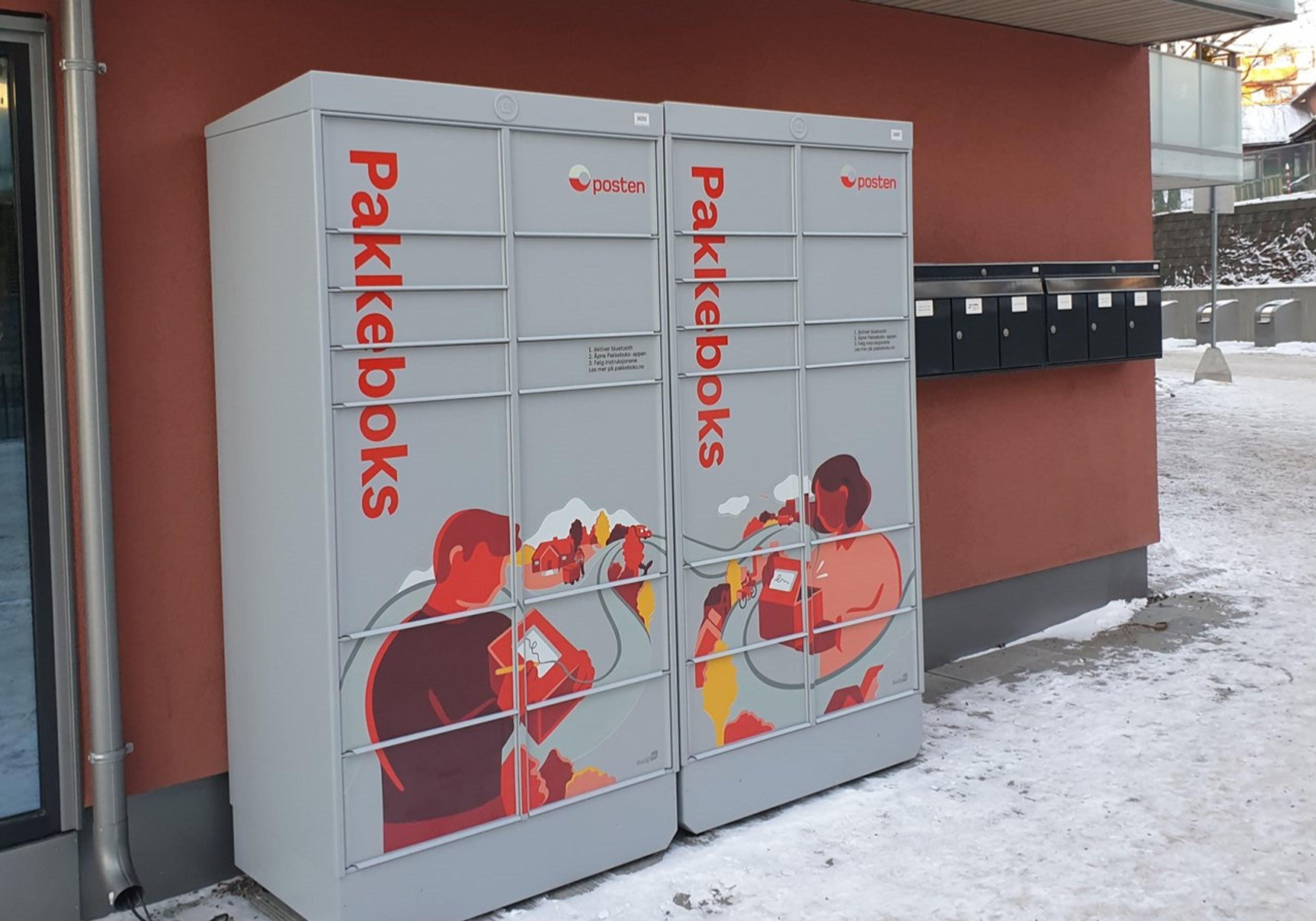 Foto av pakkebokser fra Posten utenfor en boligblokk.