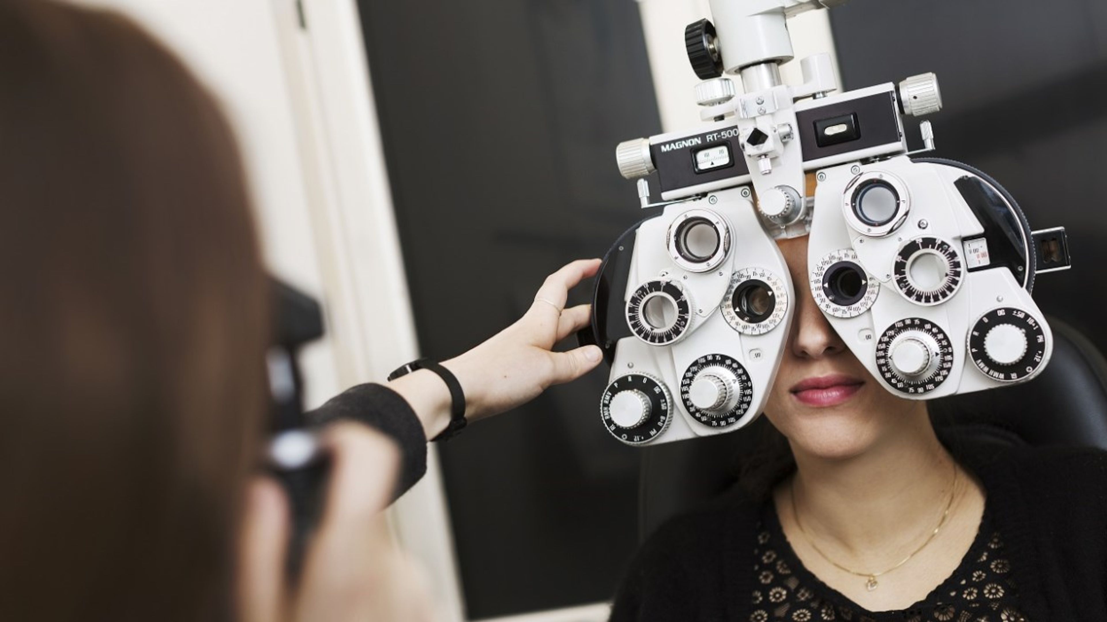 Ei dame tar en synsundersøkelse hos en optiker. Foto.