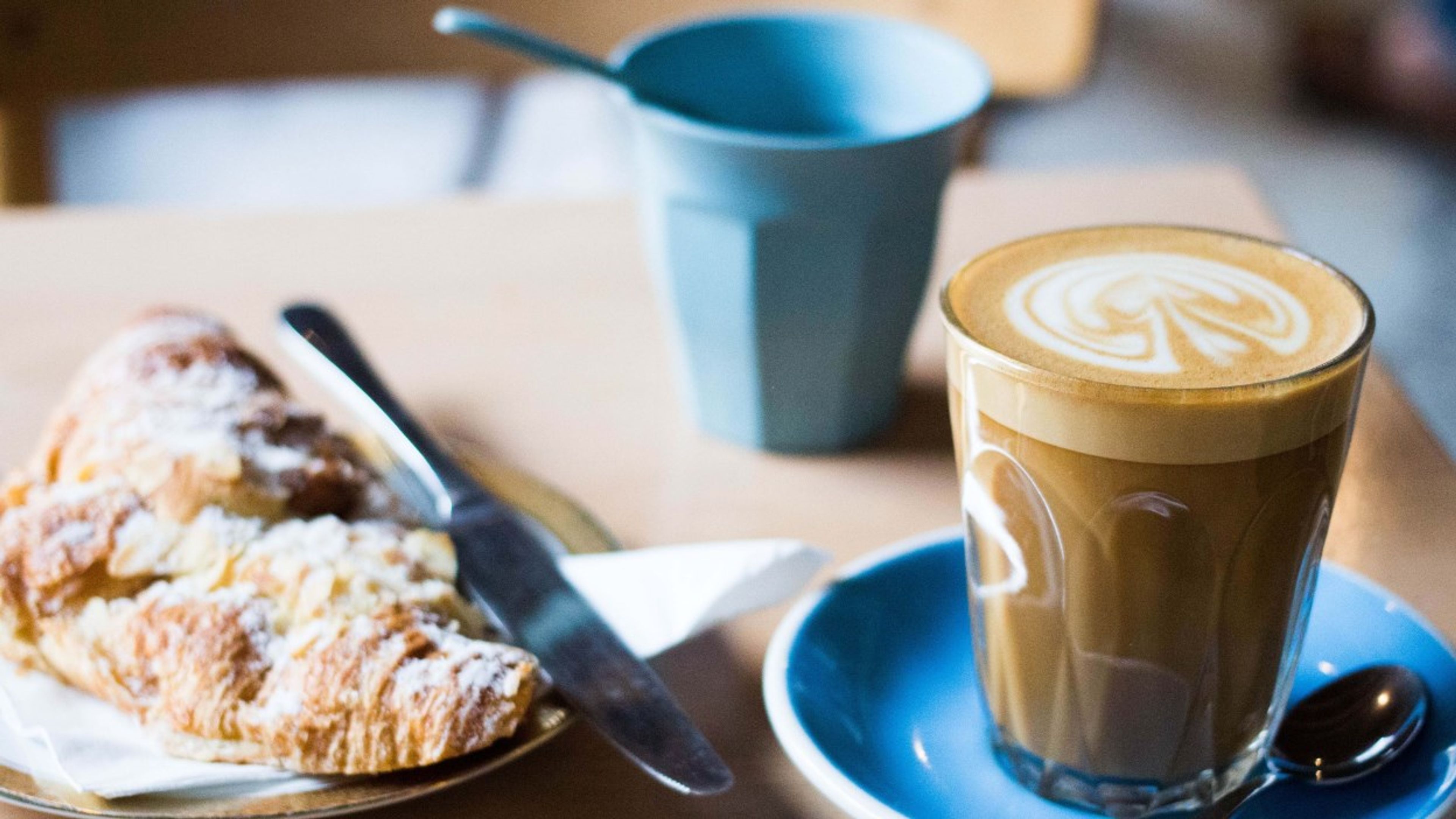 Croissant og et glass med cappuccino. Foto.