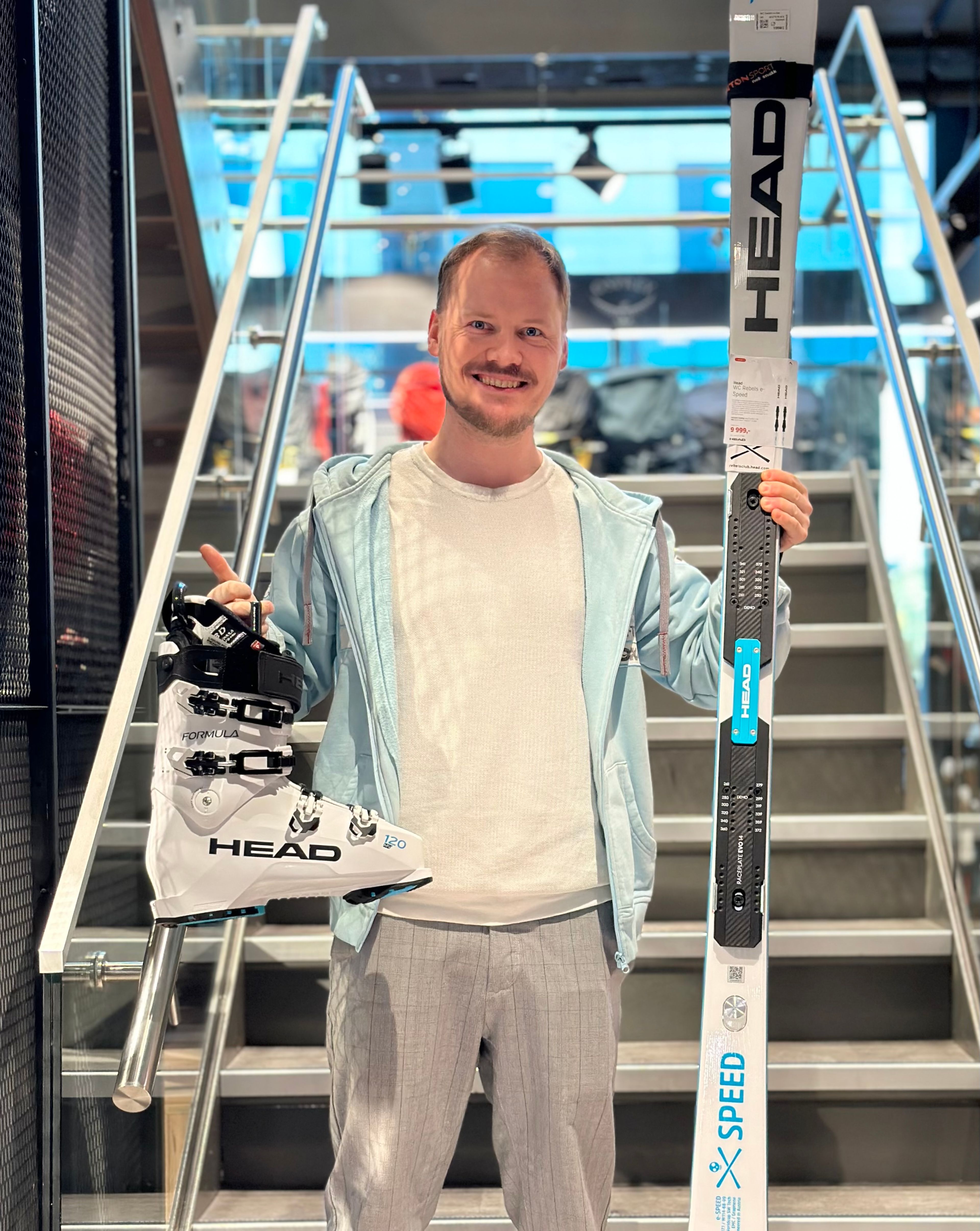 Bilde av en mann som holder opp alpintutstyr.