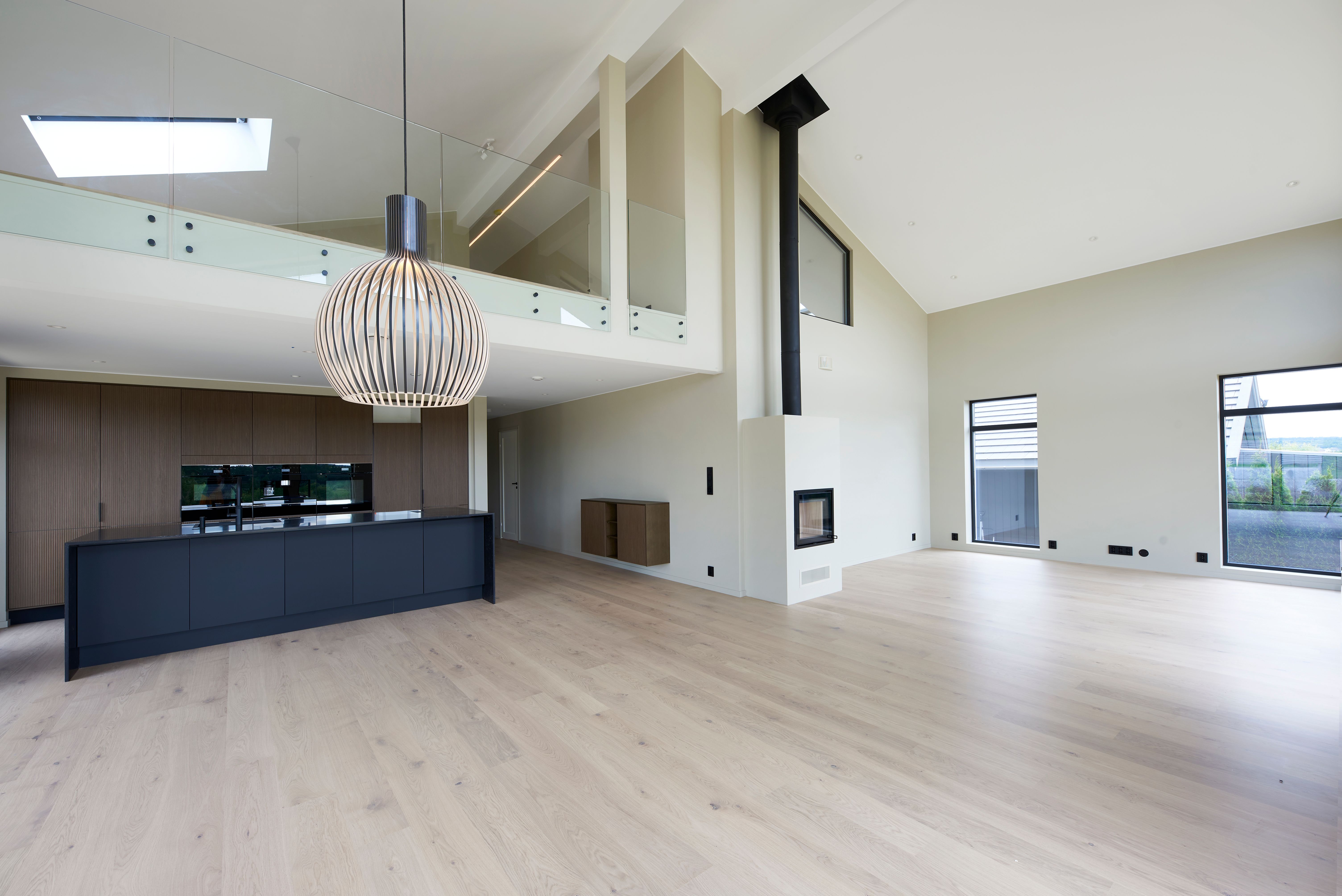 Foto av stue og kjøkken med galleriløsning over, i enebolig bygget av OBOS Block Watne Eneboliger, i Manstad, Fredrikstad