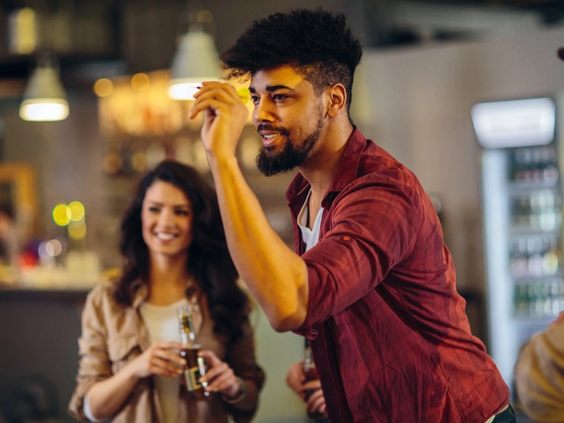 to unge mennesker som spiller dart