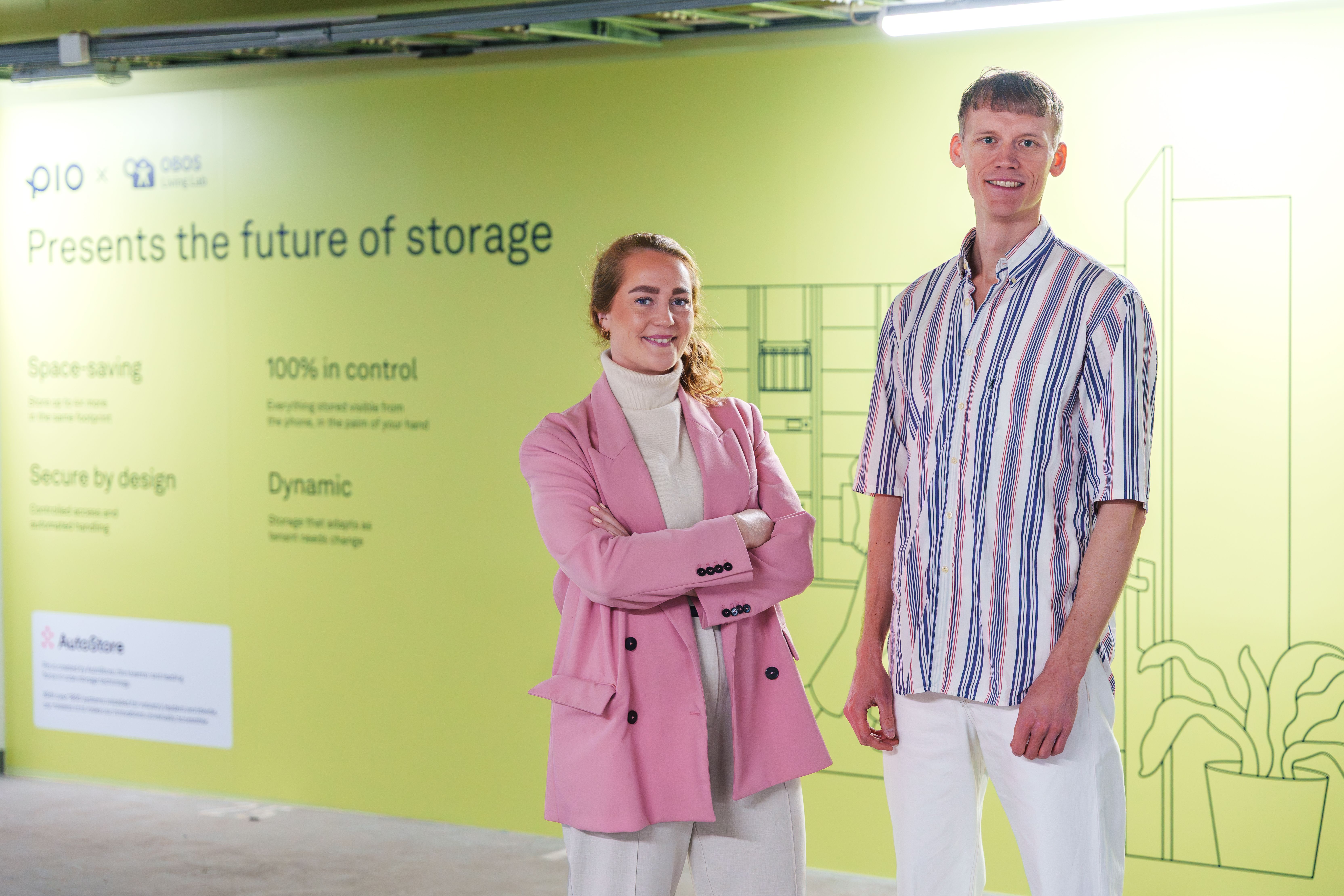søren secher og anine willums karp foran Pio – Created by AutoStore sin løsning i kjelleren til obos living lab, foto: hampus lundgren