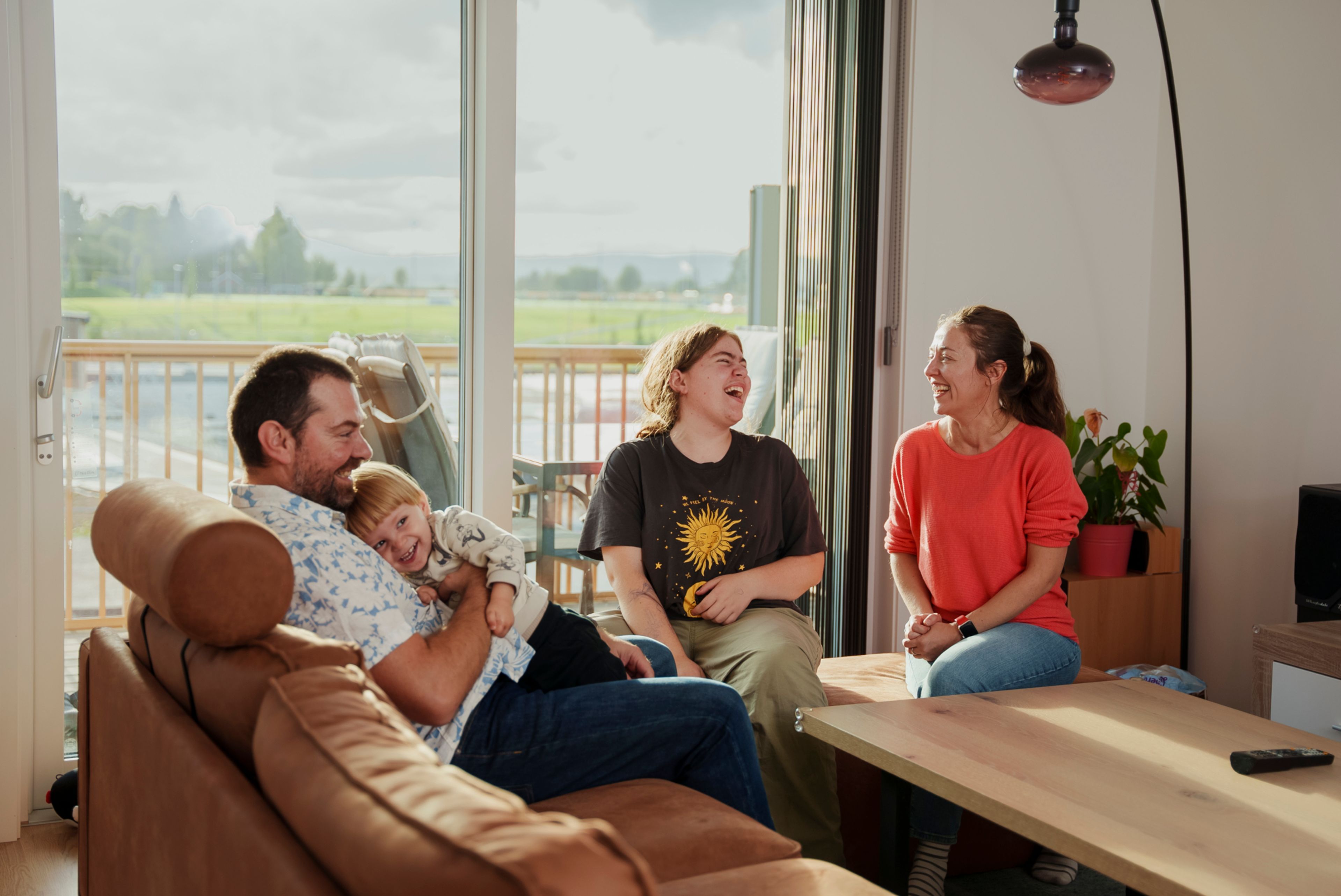 Familie sitter rundt et bord i stuen