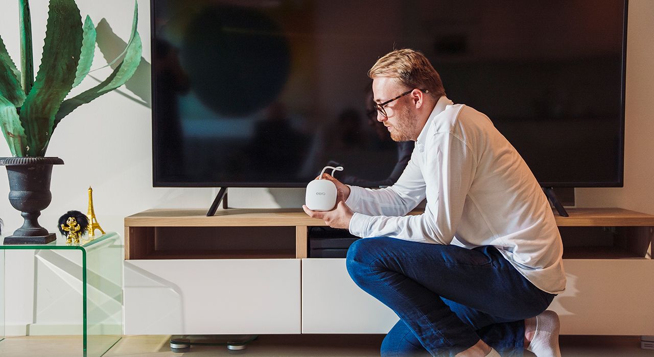 En mann setter opp TV-boksen sin.